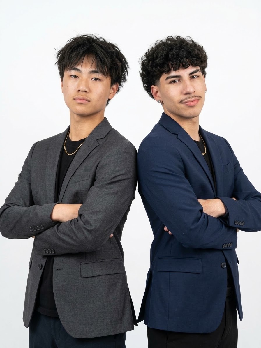 Jayden Bui, on the left in a gray blazer, standing back to back with a teammate in a navy blazer.